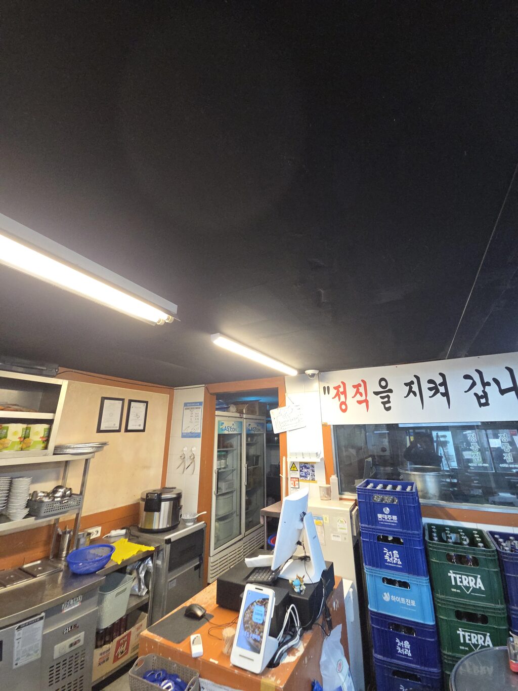 냉장 진열대와 조명이 있는 매장 내부의 텍스 천장