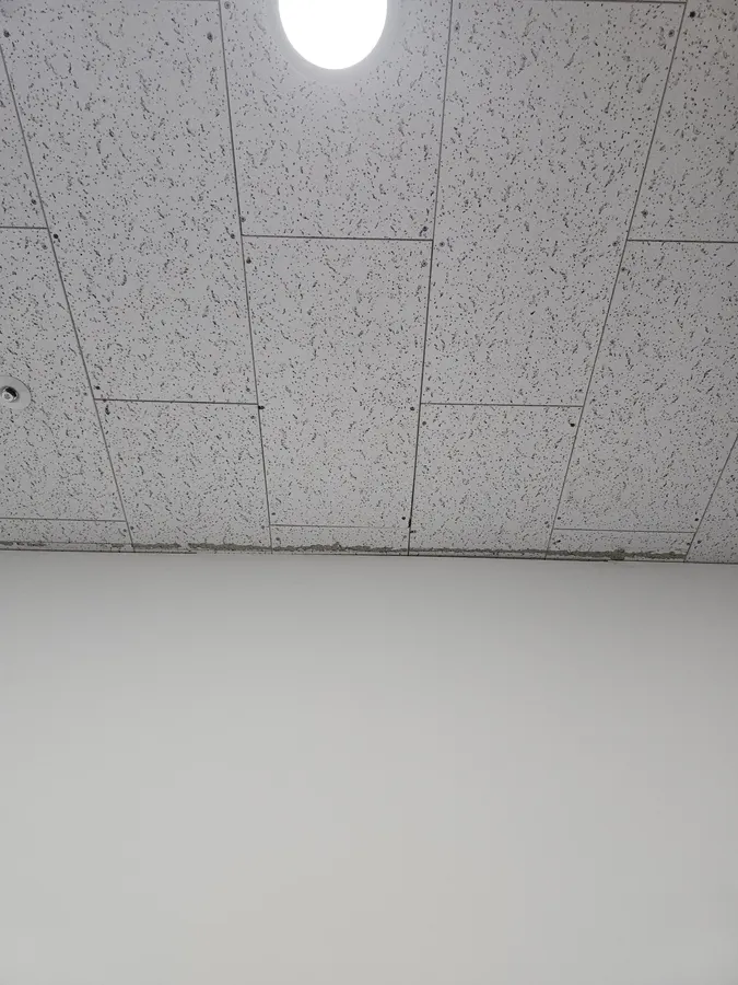 균열 무늬가 있는 텍스 천장 표면과 이어진 패널 줄눈